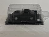 a black toy car in a clear box on a white surface