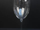 a wine glass with a reflection of a building in it