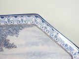 a blue and white plate with a painting on it