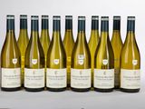 six bouteilles de vin blanc sont alignées sur une table