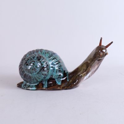 un petit escargot posé sur une surface blanche