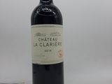 une bouteille de vin rouge avec une étiquette blanche posée sur une table