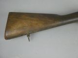an old wooden rifle with a long wooden handle on a white surface