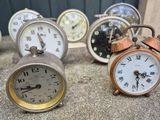many different clocks sitting on the ground next to each other