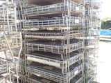 une grande pile de cages métalliques posée au bord de la route