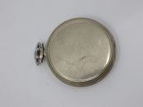 a small silver pocket watch on a white surface