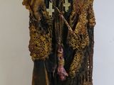 une statue représentant un vieil homme portant un chapeau et un manteau