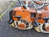 two chainsaws sitting on the ground next to each other