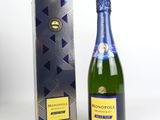 La bouteille de champagne se trouve à côté d'un carton.
