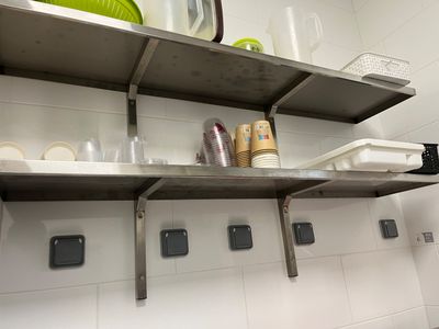 une étagère en métal sur laquelle sont posés des plats, dans une cuisine