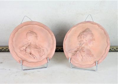 two pink plates with a picture of a man and a woman on them