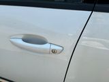 a close up of a door handle on a white car