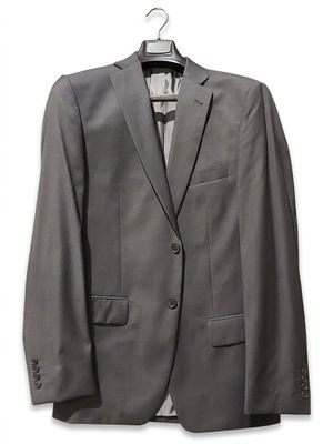 grey suit on a hanger on a hanger on a white wall