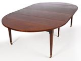 une table à manger ovale en acajou avec quatre rallonges fixées aux pieds