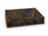 an old book with a leather cover on a white surface