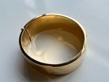 a close up of a gold ring on a white surface