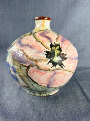un vase orné d'une fleur sur fond gris
