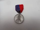 the medal is sitting on a white surface with a red and blue ribbon
