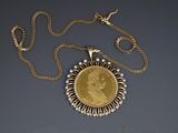 a close up of a necklace with a gold coin on a chain