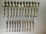 many spoons and forks arranged in a row on a table