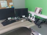 un bureau sur lequel se trouvent deux écrans d'ordinateur et un téléphone