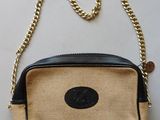 a close up of a purse on a table with a chain around it