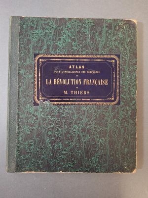 un vieux livre à la couverture verte et aux bordures dorées