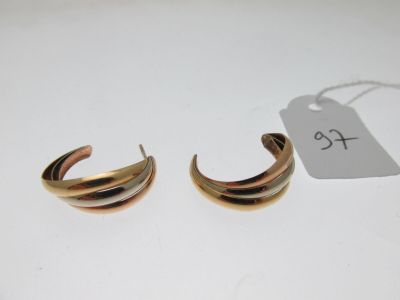 une paire de boucles d'oreilles créoles dorées avec une étiquette de prix sur fond blanc