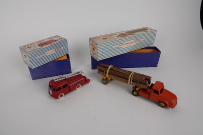 trois petites voitures et une boîte posées sur une surface blanche