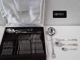 une boîte à couverts posée sur une table, contenant une cuillère et une fourchette en argent