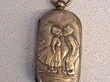 un vieux cadenas en argent sur lequel est gravé le portrait d'un homme et d'une femme