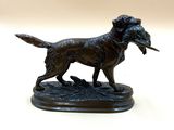 statue en bronze représentant un chien tenant un oiseau dans la gueule