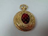 an image of a gold locke with a red stone in the center