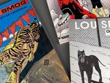 three books of comics sitting on top of a table next to each other