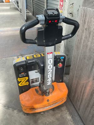 a small orange machine that is sitting on the sidewalk