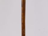 a wooden stick with a metal handle on a white surface