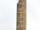 an old book that is sitting on a white surface