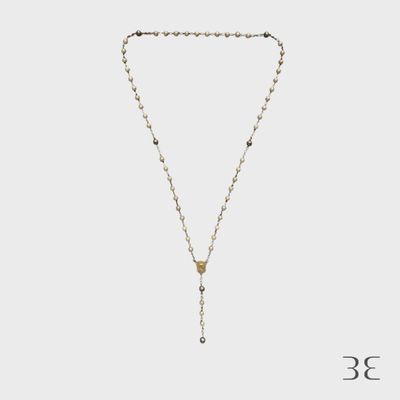 un collier composé d'une chaîne en or et d'une perle noire et blanche