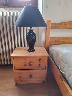 une lampe posée sur une table de chevet à côté d'un lit