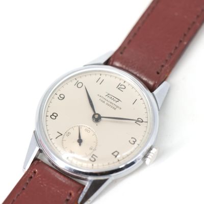 une montre en argent avec un bracelet en cuir marron sur un fond blanc