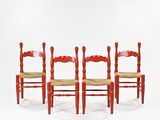 three red chairs are lined up against a white backdrop