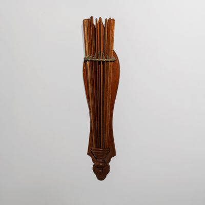 un porte-bâtons en bois sur lequel sont enfilés plusieurs bâtons