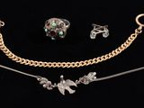 three pieces of jewelry are displayed on a black surface