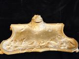 a gold plate with a frog on it on a black background