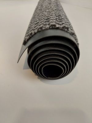 un rouleau de moquette noire et blanche posé sur une surface blanche
