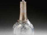 a clear glass bottle with a gold top on a table