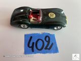 une petite voiture posée à côté d'une feuille de papier