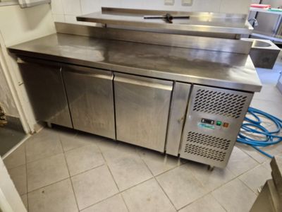 un plan de travail en acier inoxydable dans une cuisine équipée d'un tuyau bleu