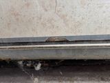 a close up of a car door with a rusted bumper