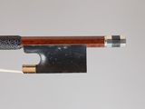gros plan d'un archet de violon avec un morceau de bois qui en sort